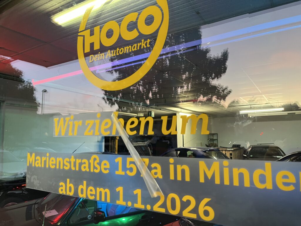 Fensterbeschriftung am alten HOCO-Standort mit den Aufschriften "Wir ziehen um" und "Marienstraße 157a in Minden ab dem 1.1.2026"